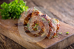 Chicken wings grilled BBQ parsley herb and sesame on wooden board