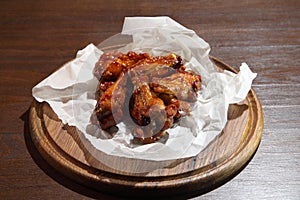 Chicken wings in hot sauce, specially prepared for beer. Chicken baked wings on wooden background.