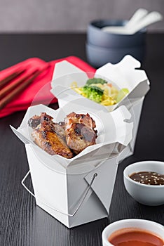 Chicken wings and noodles in take away noodles box