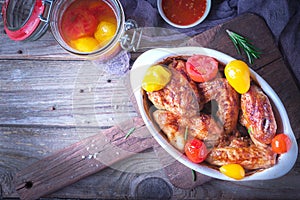 Chicken Wings, Oven Baked and Grilled. Homemade Tasty Food. Pickled colorful tomatoes.Wood Table Background, Rustic Still Life