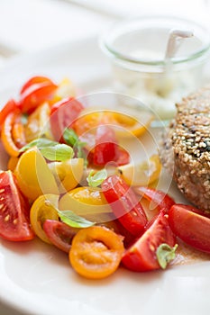 Chickenburger with tomato salad