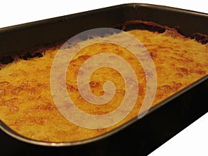 Chickpea flour pancake in a tray isolated on white background. The pancake is known as Cecina in Tuscany or Farinata in Liguria