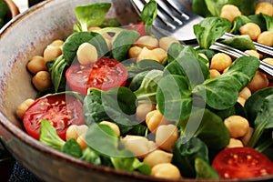 Chickpea salad with ingredient and tomatoes and lambÂ´s lettuce. healthy salad