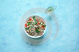 Chickpea salad with vegetables on a blue background. Summer vegetarian diet. photo