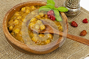 Chickpeas with curry sauce in wooden bowl. Studio Photo