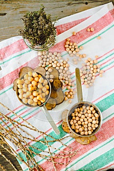 Chickpeas dry and boiled in an iron bowl, thyme. Rustik style background. Top view.