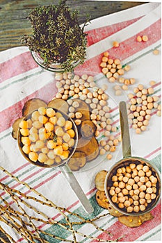 Chickpeas dry and boiled in an iron bowl, thyme. Rustik style background. Top view. Kinfolk and comfort food atmosphere concept.