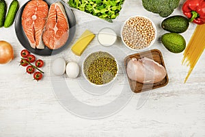 Chickpeas, fish, eggs, cheese and vegetables on a light background, flat lay. The concept of proper nutrition, a