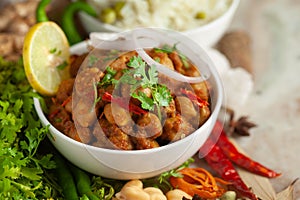 Chickpeas masala Spicy chola or chhole curry  garnished with fresh green coriander and ingredients. Served in a ceramic bowl.