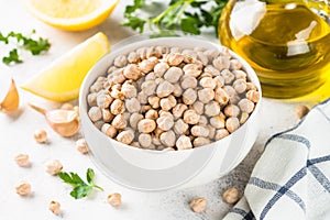 Chickpeas in white bowl at light kitchen table.