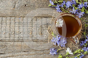 Chicory drink in Cup and flowers on rustic wooden background. Me