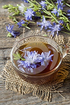 Chicory drink in Cup and flowers on rustic wooden background. Me