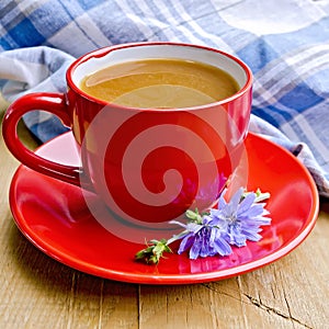 Chicory drink in red cup with napkin on board