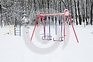 Chidren playground covered snow with colorful swing photo