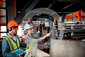 Chief engineer is looking at a work that he is checking security system setup at metal lathe industrial manufacturing