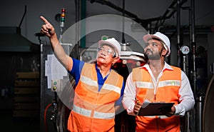 Chief engineer of a mechanical plant Inspecting and explaining the maintenance of the machine to the mechanic