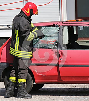 Chief fireman while breaking the glass of a car with a special e