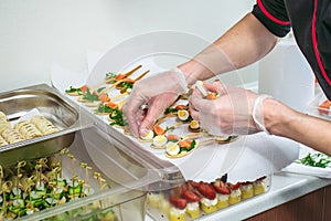 Chief at kitchen prepareing delicates, appetizers. Catering service. Closeup shoot of hands.