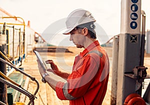 Chief officer or captain on deck of vessel or ship watching digital tablet