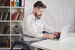Chief sitting in a wheelchair and working on a laptop