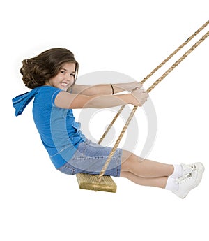 Cute Caucasian child playing on a wooden swing