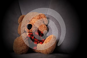 Child abuse concept. Teddy bear sits on the sofa