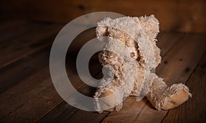 Child abuse.Teddy bear covering eyes, dark empty background, copy space photo