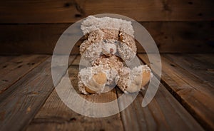 Child abuse.Teddy bear covering eyes, dark empty background, copy space photo