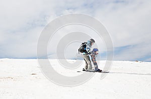 Child and an adult in warm overalls, skiing