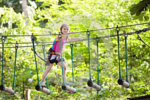 Child in adventure park. Kids climbing rope trail