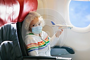 Child in airplane in face mask. Virus outbreak