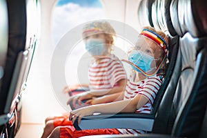 Child in airplane in face mask. Virus outbreak photo