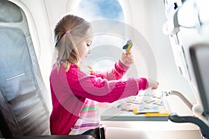 Child in airplane. Fly with family. Kids travel.