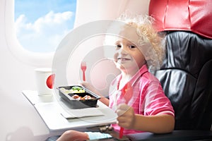 Child in airplane. Kids fly. Children flight meal