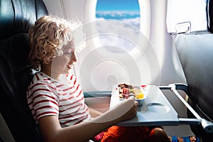 Child in airplane. Kids fly. Children flight meal