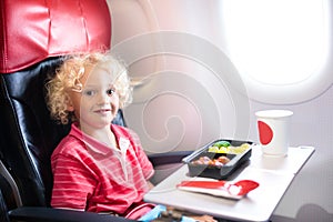 Child in airplane. Kids fly. Children flight meal