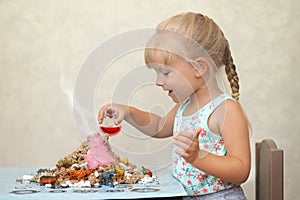 Child amused by a home made volcanoe