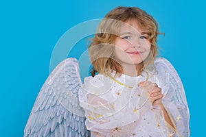 Child at angel costume. Kid with angel wings with prayer hands, hope and pray concept. Isolated studio shot.