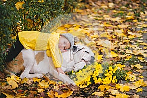 Child with apple having rest next to big dog