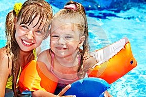 Child with armbands in swimming pool