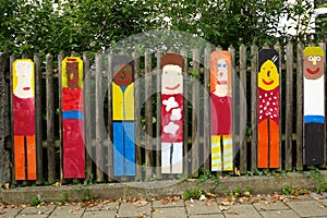 Child art displayed on wooden fence