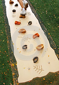 Child on artificial rock climbing equipment