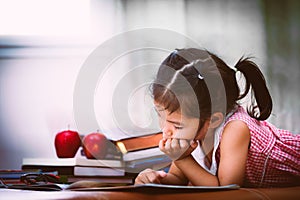 Child asian little girl is bored to read a book