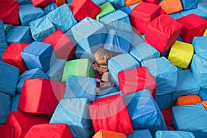 Child autism Child psychology conceptual. Boy covered up with colorful soft blocks, cubes. Children`s physiological and