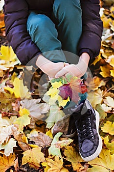 Child with autumn leaves in hand