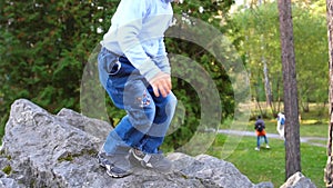 The child in the autumn Park fun playing and laughing, walking in the fresh air. The boy climbs large stones, he likes