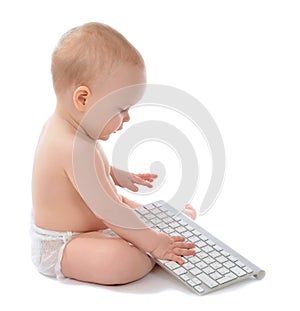 Child baby boy sitting hands typing wireless computer keyboard