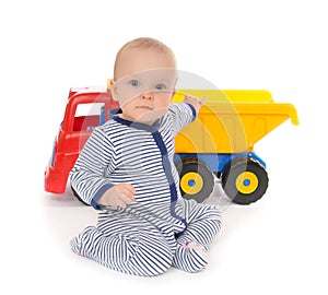 Child baby boy toddler happy sitting with big toy car truck