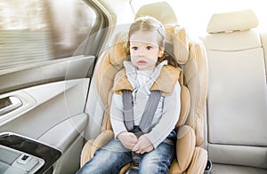 Child in a baby car seat. Isofix clamping. beige car seat in a bright salon. Protection in the car. photo