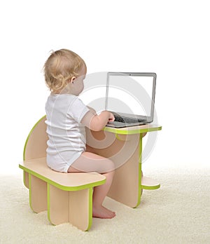 Child baby girl toddler typing on modern computer laptop keyboard